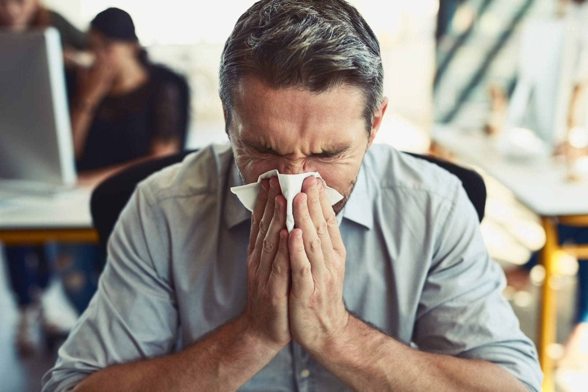 Man sneezing because of allergies Man sneezing because of allergies