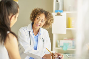 female nurse happily chatting to patient .