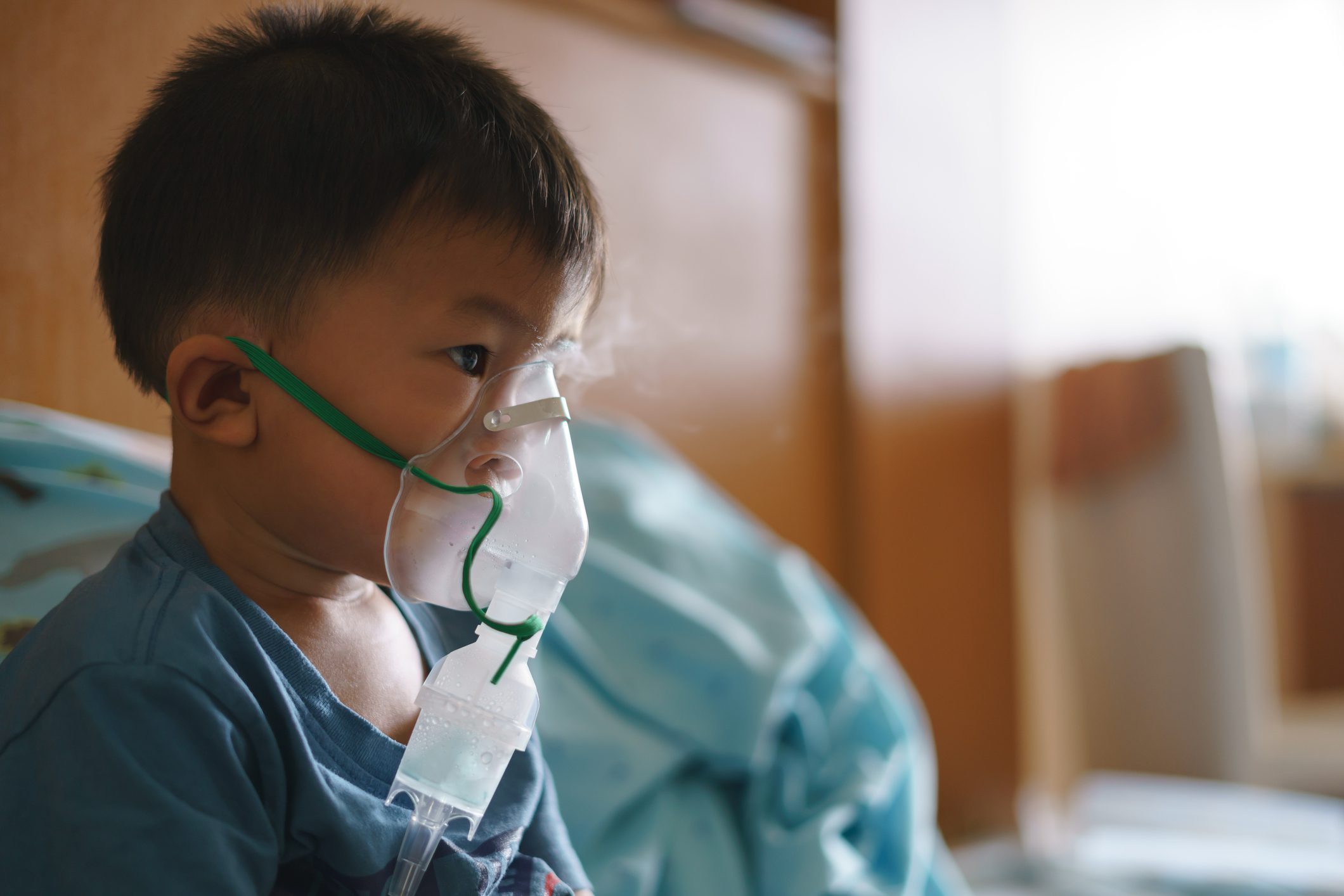 Boy using inhaler containing medicine to stop coughing Boy using inhaler containing medicine to stop coughing
