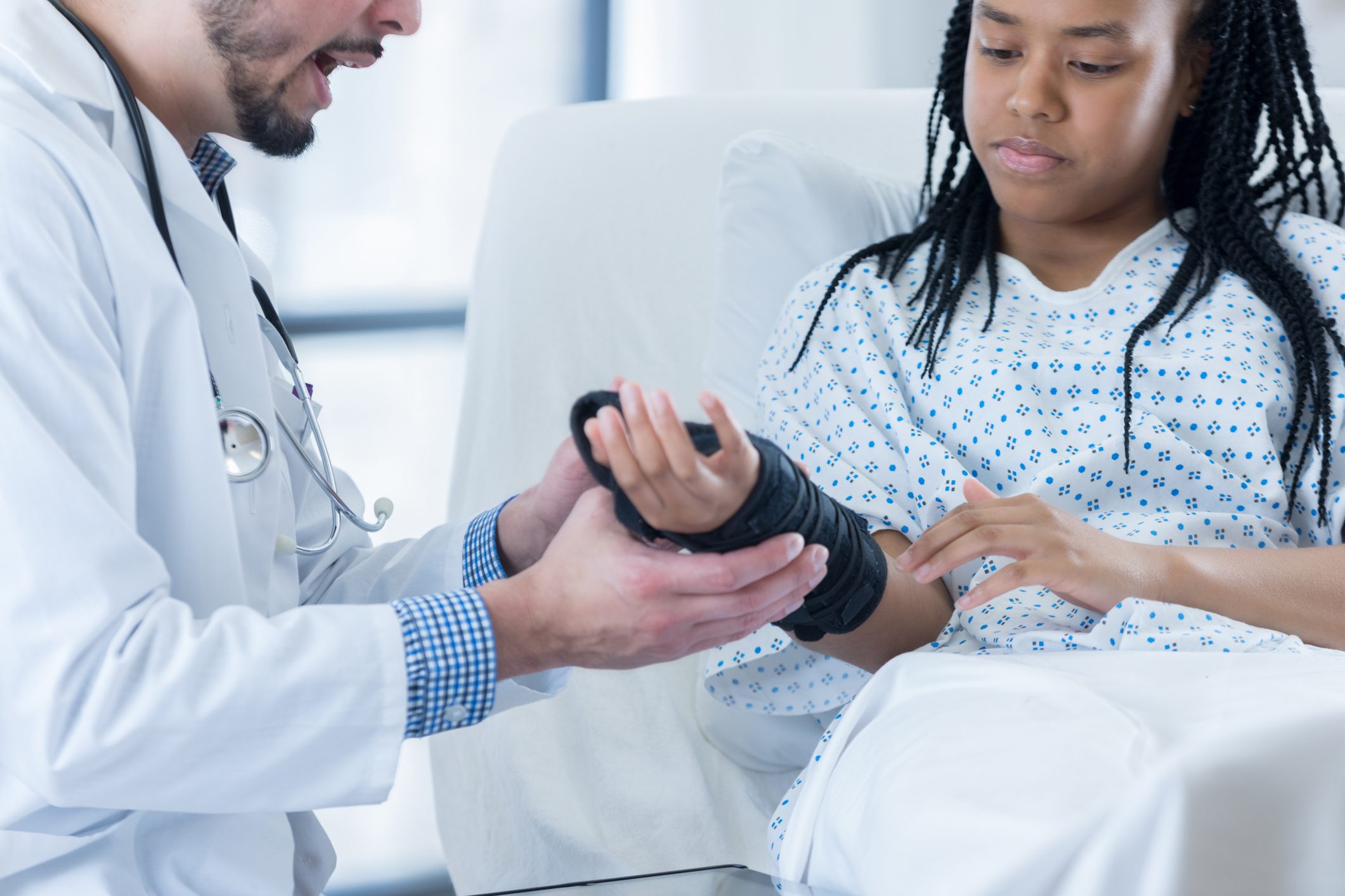 Teen hospital patient learns how to wear wrist brace Teen hospital patient learns how to wear wrist brace