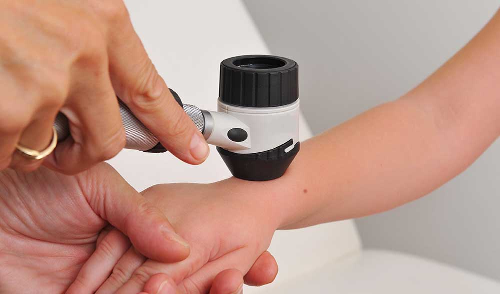 Doctor checking child’s arm for abscess or cyst Doctor checking child’s arm for abscess or cyst